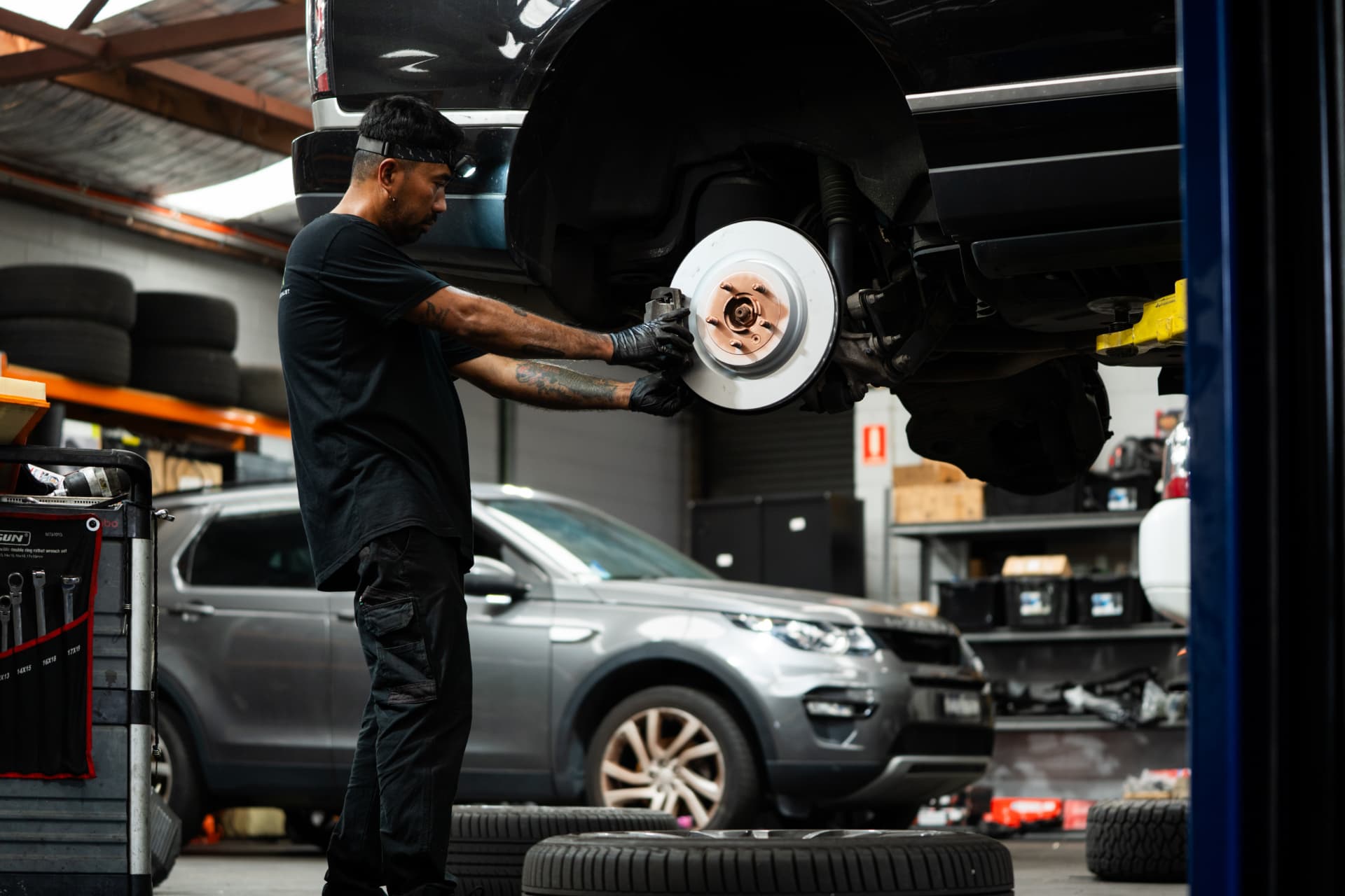 Technician replacing brake rotors on a Land Rover