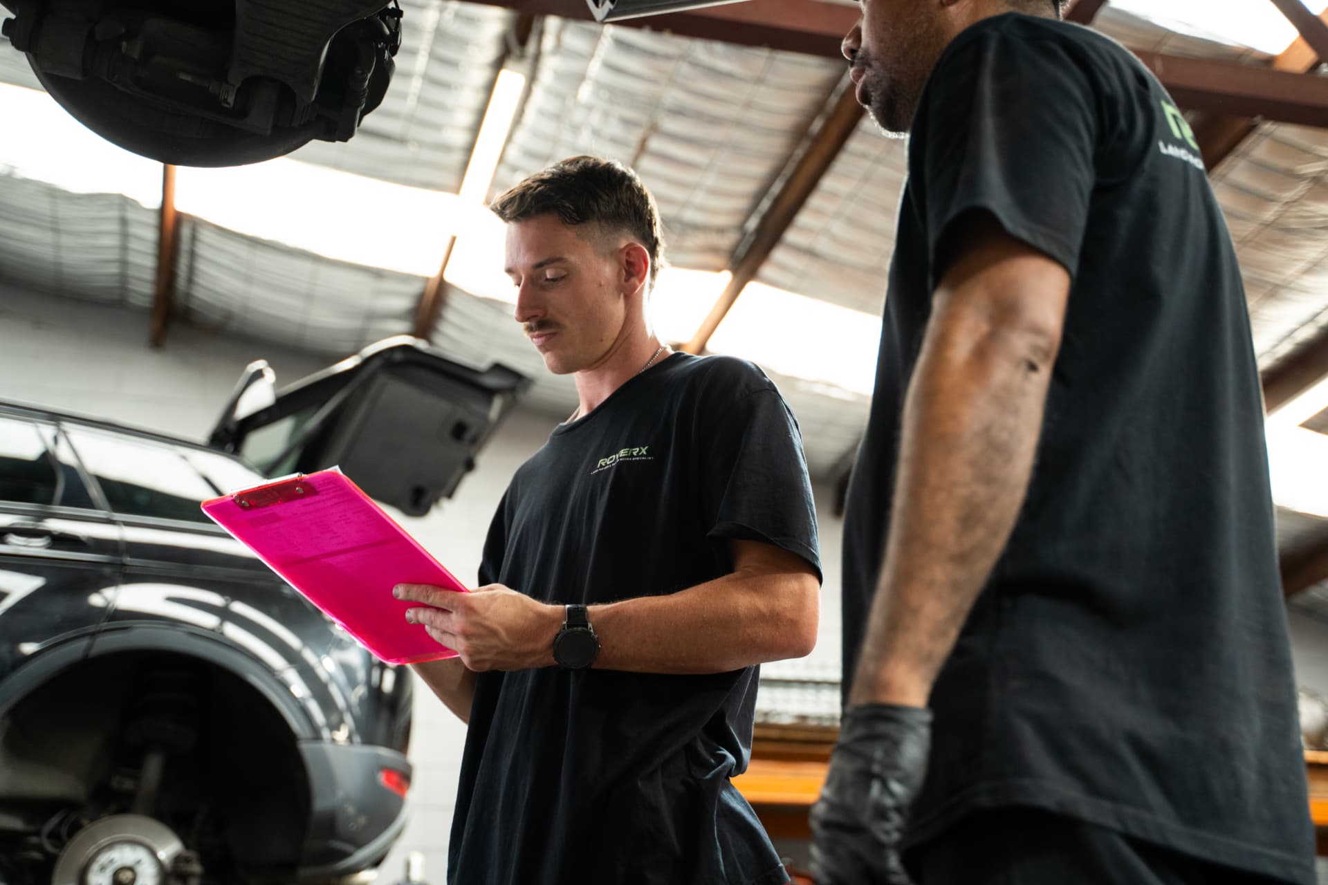 Two RoverX technicians going through a vehicle inspection sheet